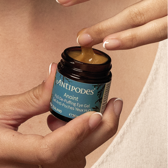 Application du gel contour des yeux Anoint d'Antipodes, main féminine prélevant la texture