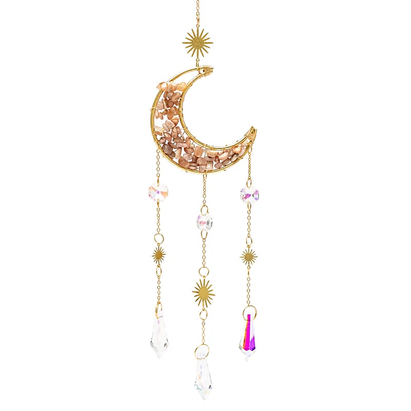 Gros plan sur un attrape-soleil doré en forme de croissant de lune, garni d'éclats de pierre de lune rose, avec trois chaînes pendantes ornées de soleils dorés et de pendentifs en cristal de roche facetté