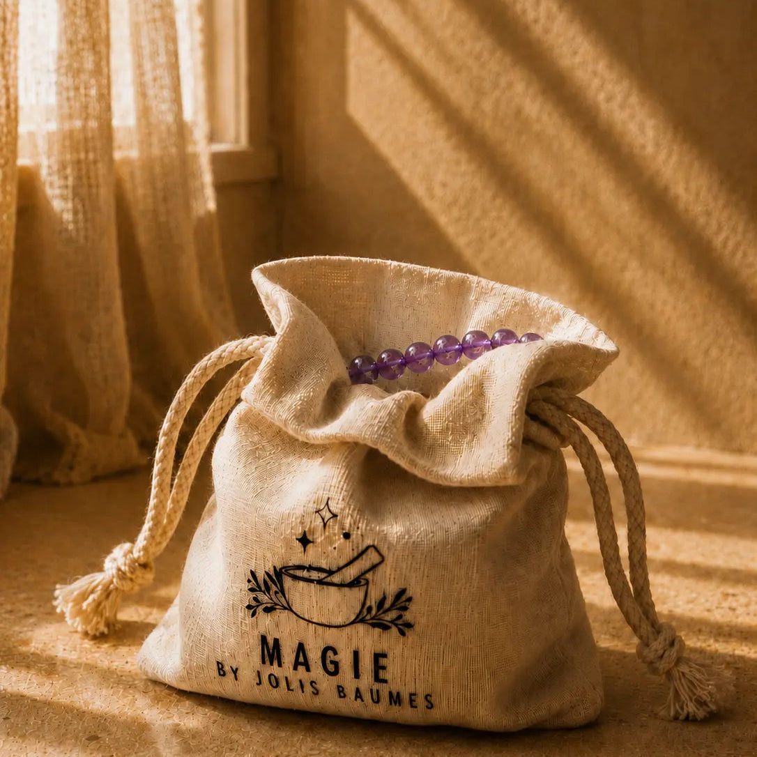 Bracelet en améthyste dans un pochon en tissu écru Magie by Jolis Baumes éclairé par le soleil