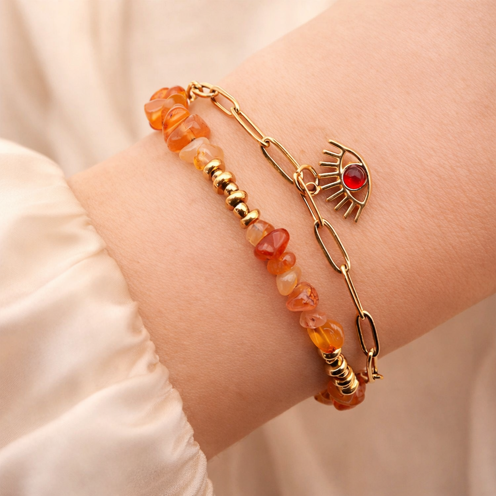 Bracelet double rand en cornaline et chaîne dorée avec oeil d'horus, sur poignet féminin avec manche en soie ivoire