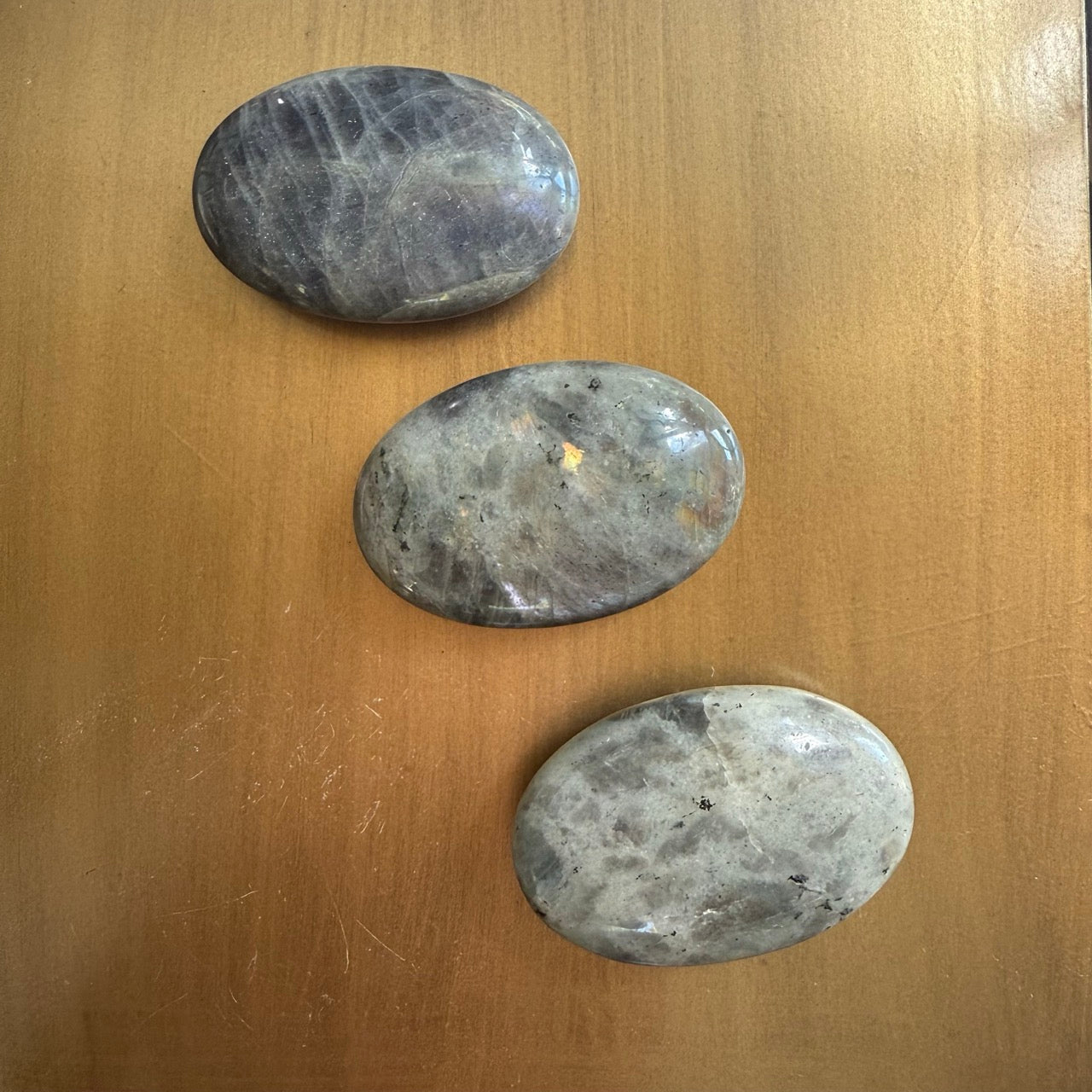 3 galets en pierre naturelle de labradorite gris et verts avec reflets dorés, sur fond métal doré, protection énergétique, De A à KA
