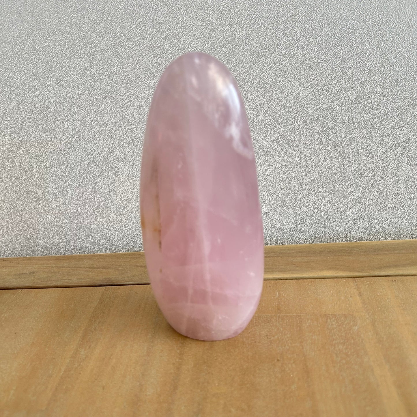 Quartz rose en forme de
dolmen posé sur une table en bois clair