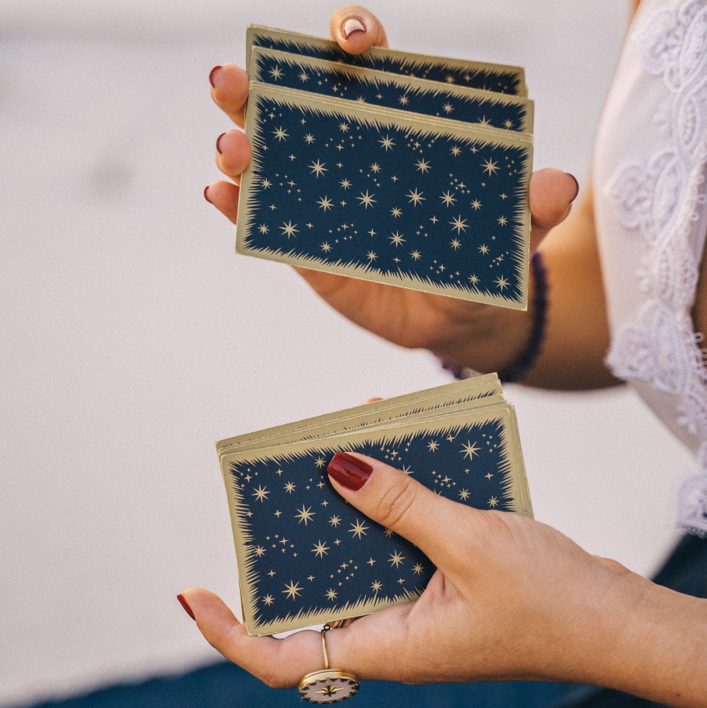 Médium battant un jeu de tarot bleu nuit étoilé, dans le cadre d'une consultation de voyance