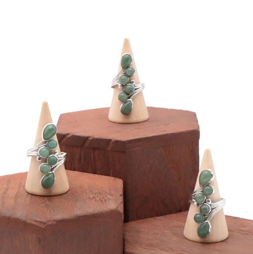 3 bagues en argent et aventurine verte sur des présentoirs coniques en bois naturels
