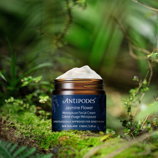 Pot de la crème visage ménopause Jasmine Flower Antipodes posé en pleine nature sur un lit de mousse