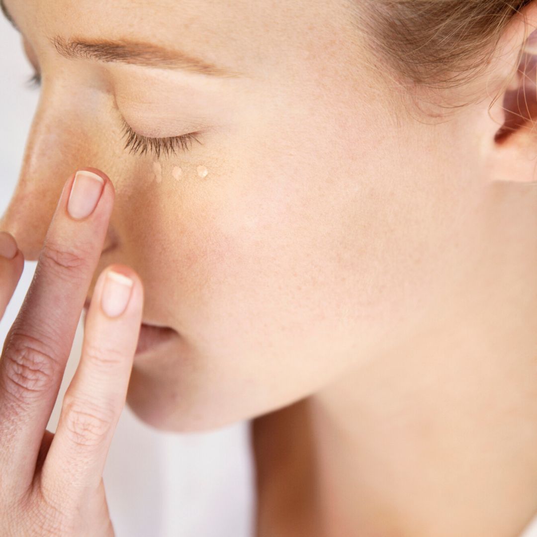 Femme appliquant la crème contour des yeux Antipodes du bout des doigts