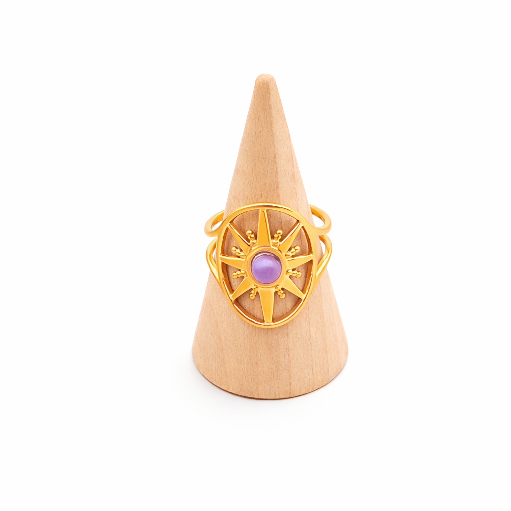 Bague améthyste au centre, monture en forme d'étoile en acier inoxydable doré, réglable, sur socle en cône de bois
