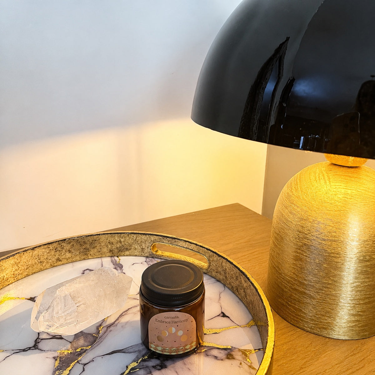 Bougie parfumée Lunar Lavender Carnatia dans son pot en verre ambré posée sur un plateau décoratif avec un quartz et une lampe dorée dans une ambiance chaleureuse