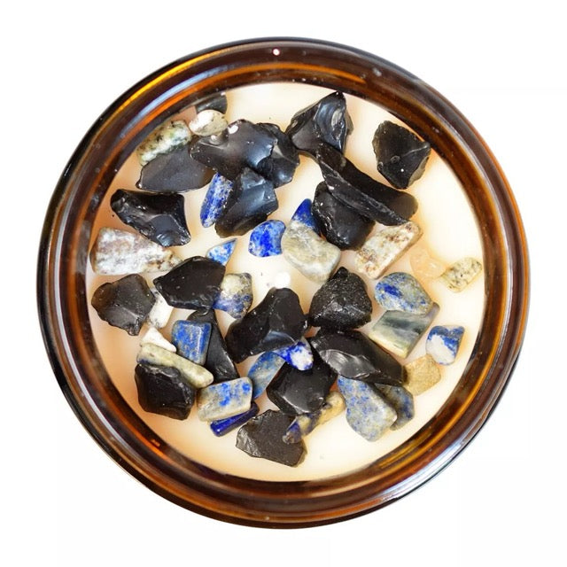 Photo vue de dessus d'un pot en verre brun de bougie avec mèche blanche, cristaux de lapis lazuli et d'obsidienne noire