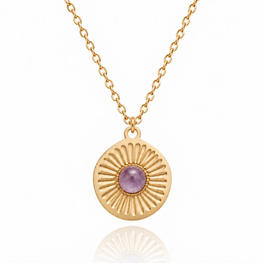 Collier doré avec pendentif soleil rond serti d’une améthyste violette sur fond blanc