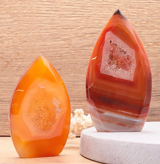 Deux tranches de cornaline en forme de flamme sur socle blanc et bois