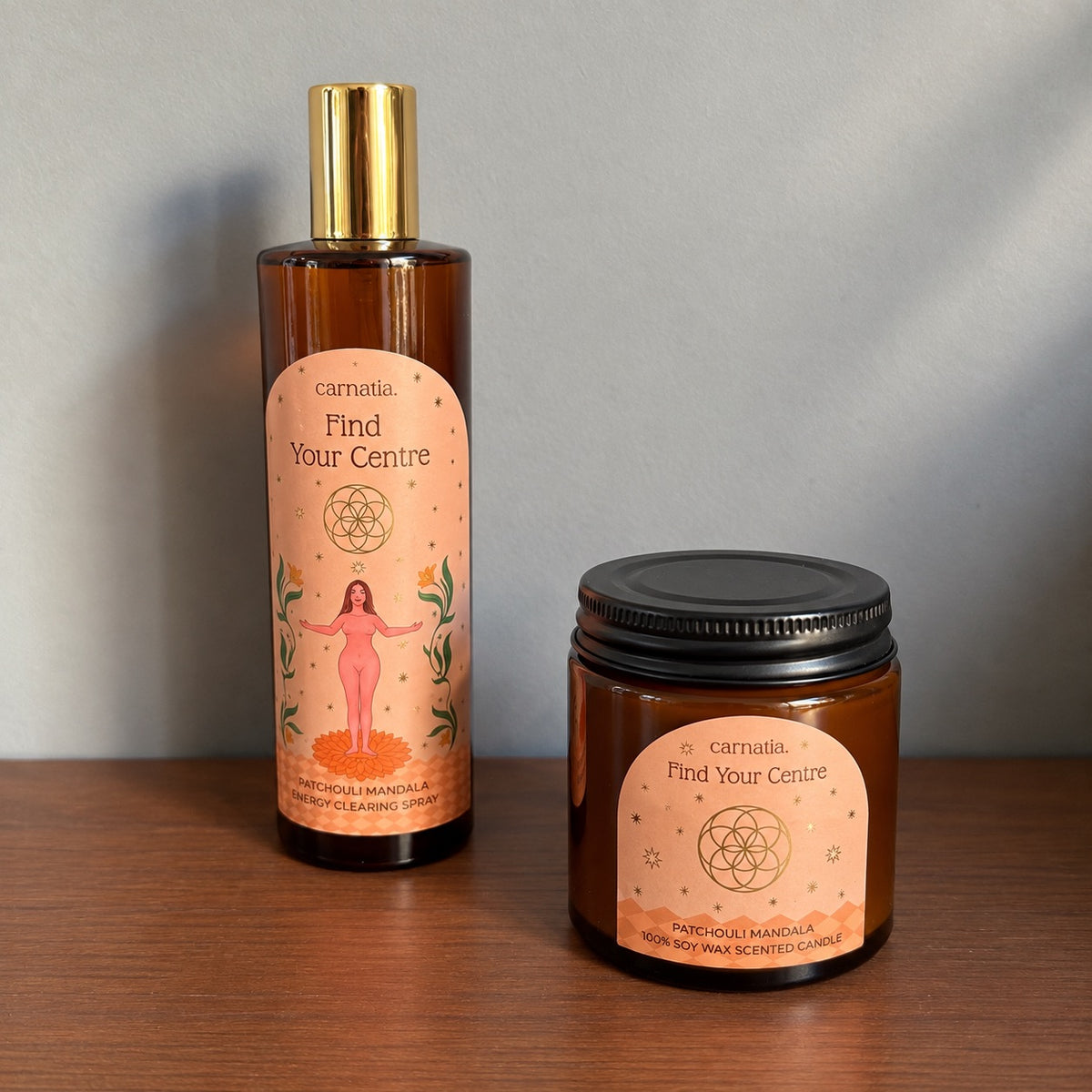 Duo Carnatia Find Your Centre sur étagère en  bois, spray d'ambiance patchouli mandala et bougie parfumée en cire de soja assortie, flacons ambrés à l'étiquette rose ornée d'une fleur de vie dorée