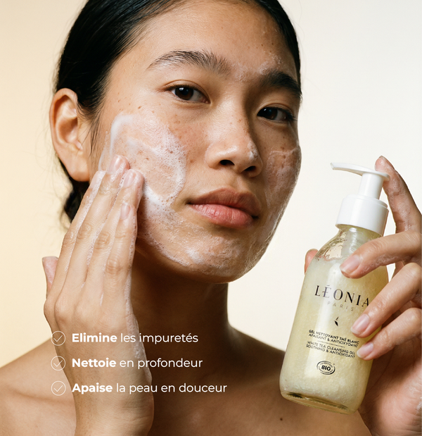 Femme appliquant le Gel Nettoyant Thé Blanc bio Léonia sur son visage, mousse douce, élimine les impuretés, nettoie en profondeur, apaise la peau en douceur