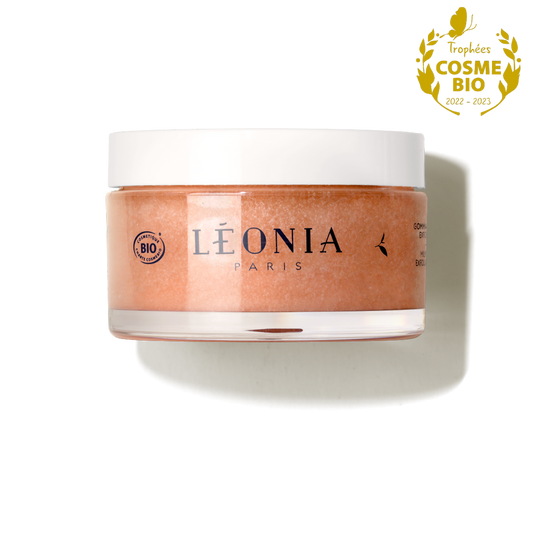 Gommage corps bio Thé Blanc Lacté 200 ml Léonia Paris, cosmétique BIO certifié Cosmos, lauréat Trophées Cosmébio 2022 et 2023, pot transparent avec couvercle blanc, grains abricots
