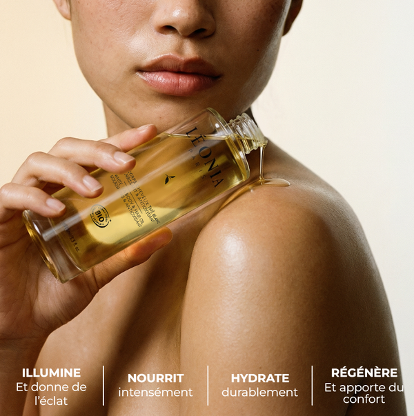 Femme appliquant l’huile corps et cheveux au thé blanc Léonia sur son épaule, bienfaits en blanc en bas de la photo