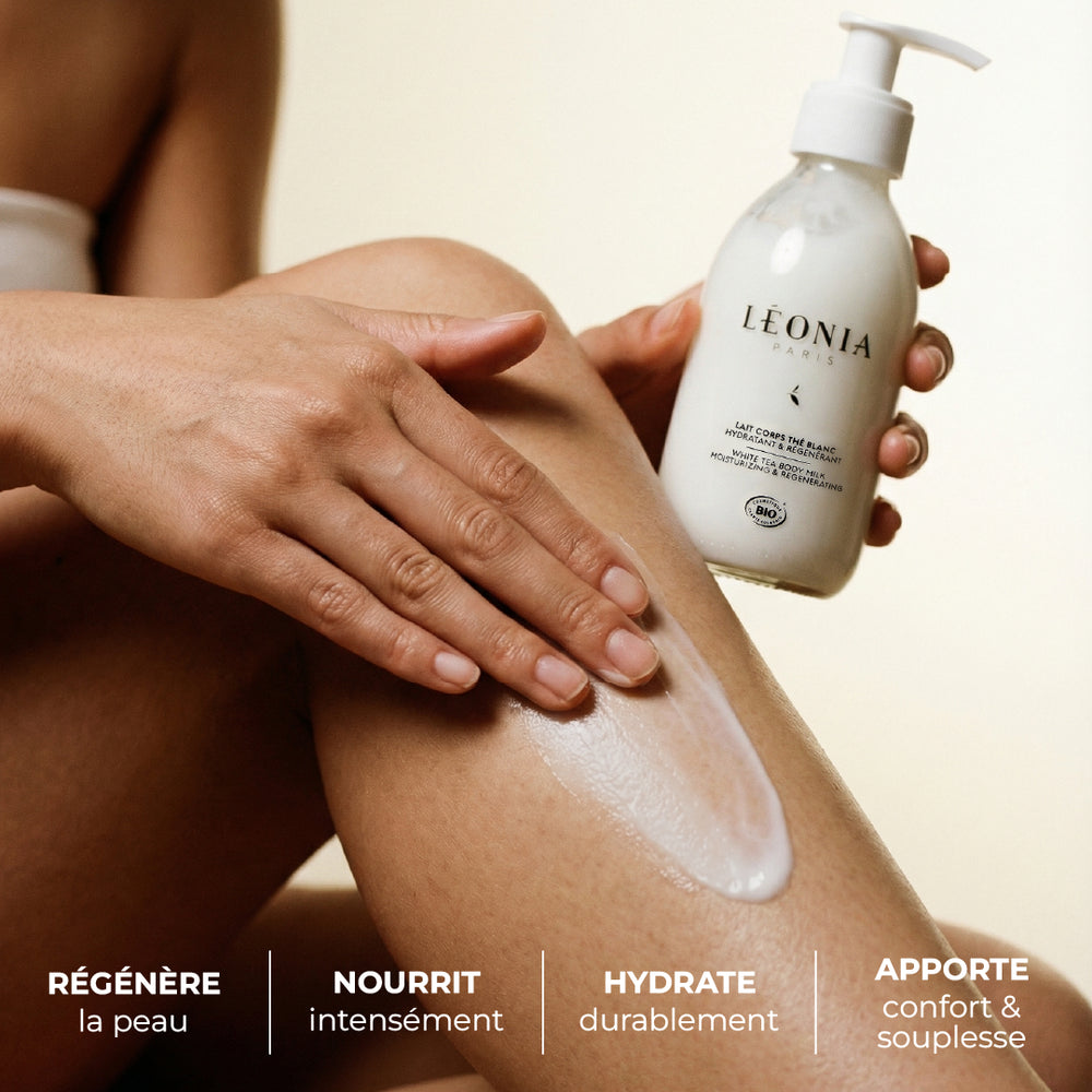 Personne appliquant du lait pour le corps sur sa jambe avec le flacon Léonia Paris, bénéfices régénère nourrit hydrate et apporte confort et souplesse affichés sur l’image