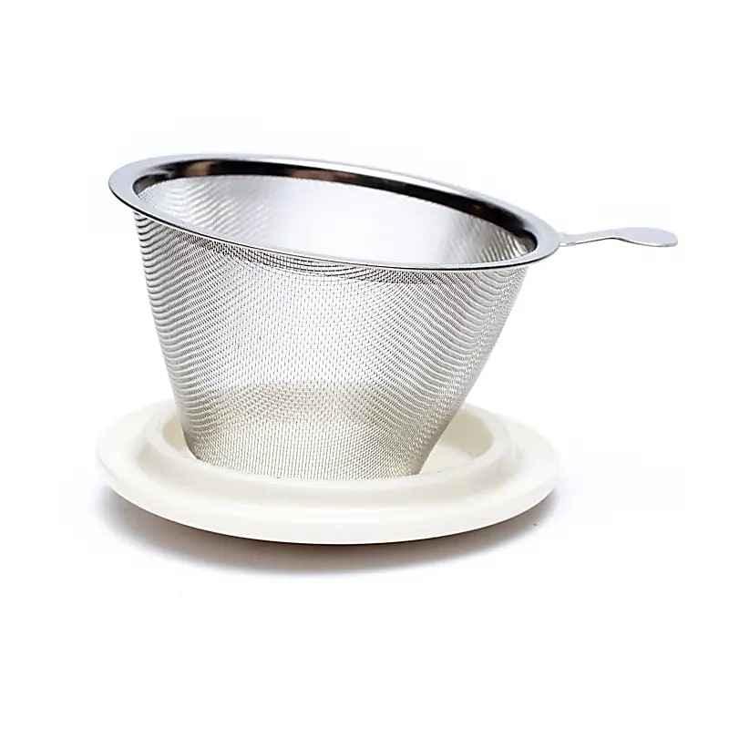 Infuseur métallique en maille posé sur le couvercle blanc de la tasse