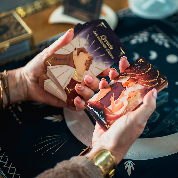 Mains de femme tenant un jeu d'oracle, tapis de divination