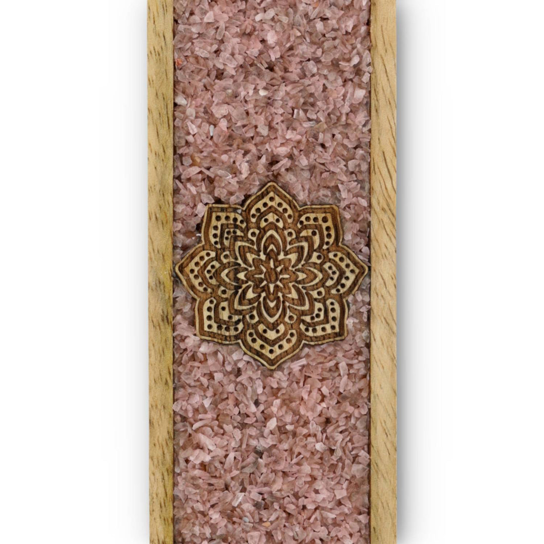 Gros plan sur le mandala en bois et les éclats de quartz rose d'un porte encens en bois de manguier