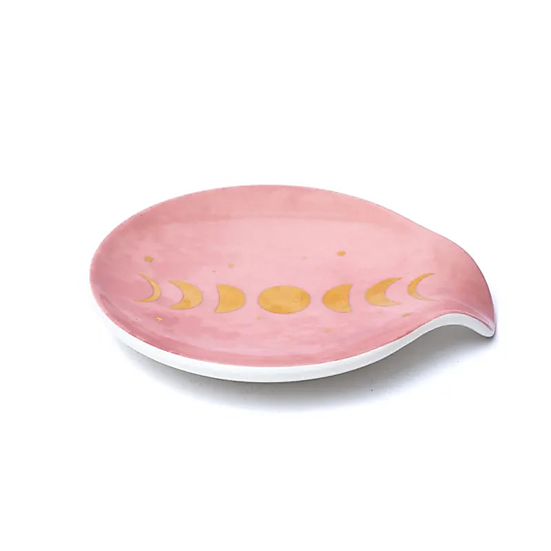Coupelle porte sachet de thé en porcelaine rose poudrée avec motif phases de la Lune dorées, vue de côté sur fond blanc