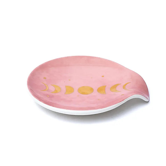 Coupelle porte sachet de thé en porcelaine rose poudrée avec motif phases de la Lune dorées, vue de côté sur fond blanc