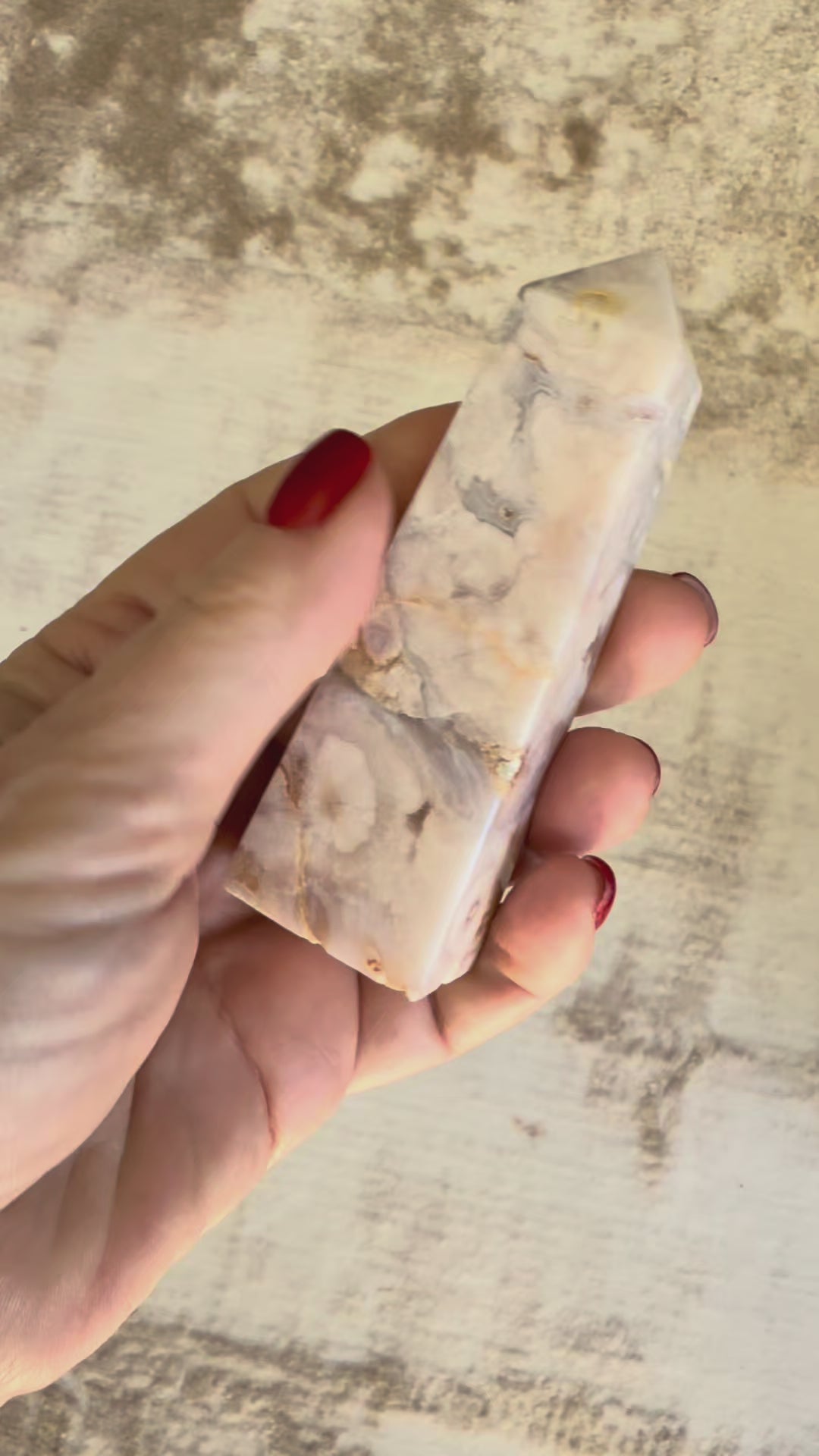 Vidéo d'une tour d'améthyste lavande drusée tenue dans la main, tournée lentement pour révéler ses nuances pastel