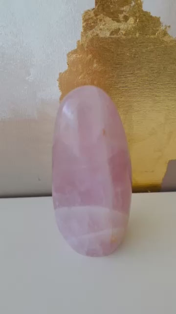Vidéo quartz rose forme libre, féminin sacré, amour inconditionnel, étagère blanche et toile dorée en arrière-plan