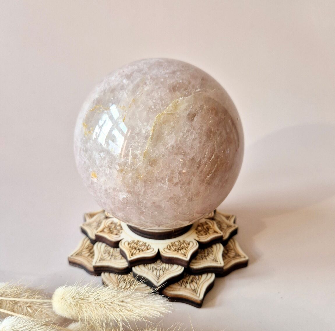 Sphère en quartz guérisseur doré xl posée sur un socle en bois avec herbes séchées pierre énergétique de guérison et d'ancrage