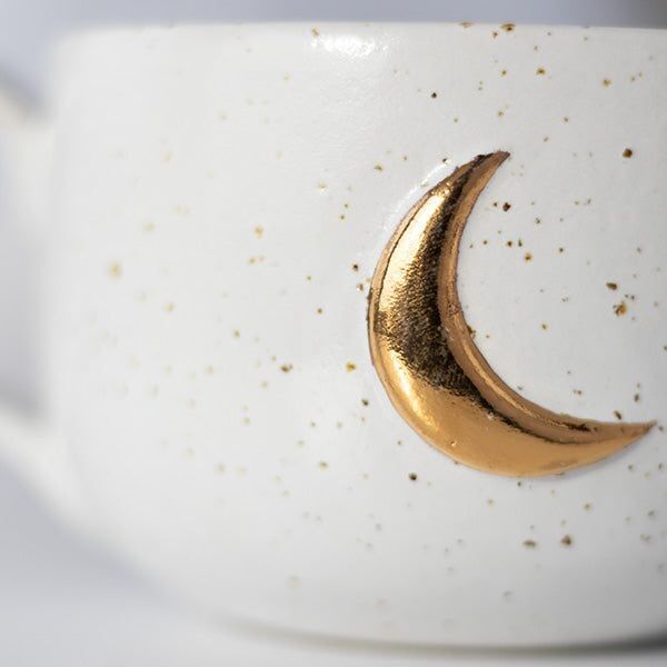 Zoom sur lune une dorée sur une tasse en grès beige moucheté