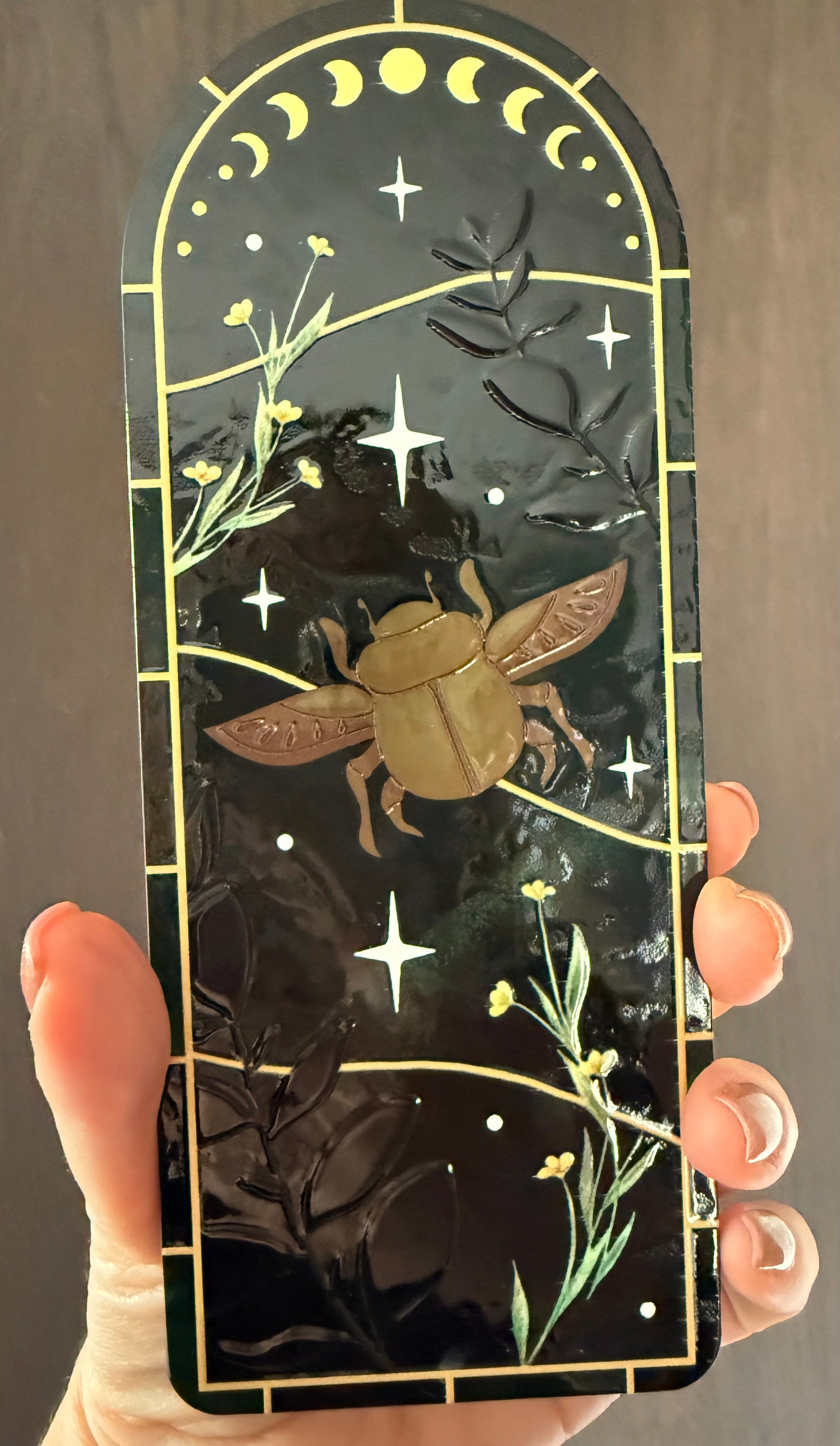 Vitrail vert et jaune doré avec étoiles et fleurs dans une main de femme